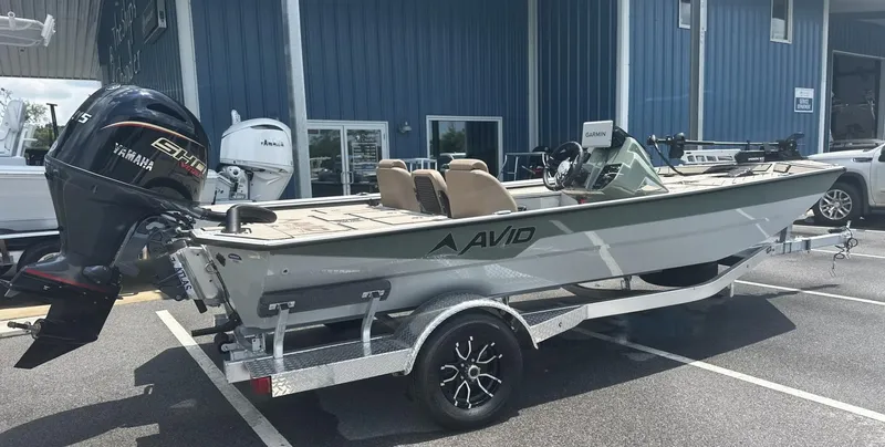 Slide: The Image of 2025 Avid 18 Vertex boat on trailer with Yamaha engine, parked outside blue building. - 21