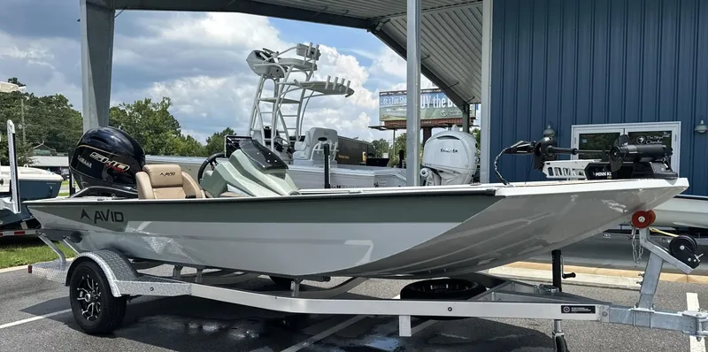 Slide: The Image of Avid 18 Vertex 2025 boat on trailer, outdoor display, Yamaha engine, blue building background. - 22