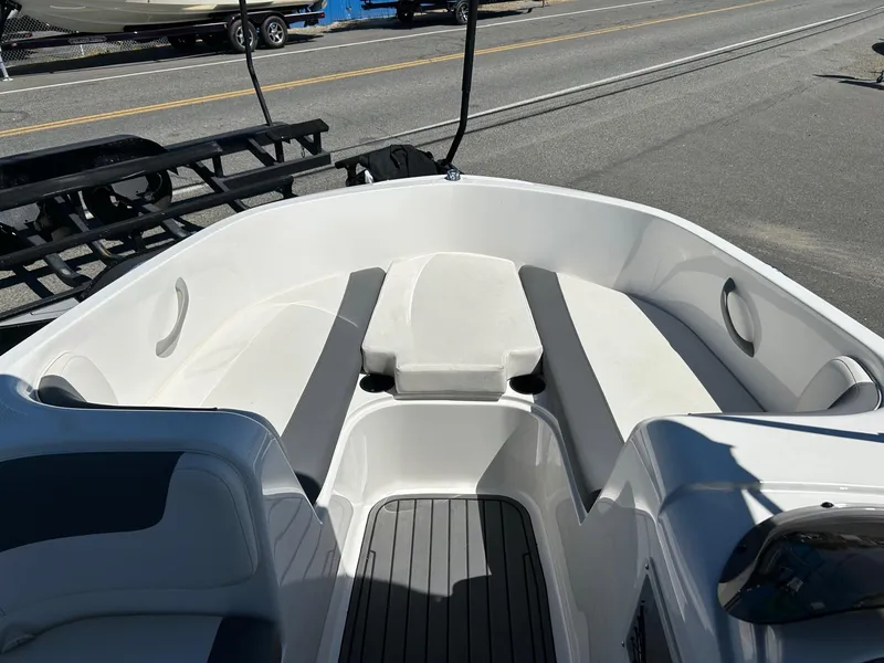 Slide: The Image of 2020 Bayliner Element E18 boat interior with white seating and gray flooring. - 10