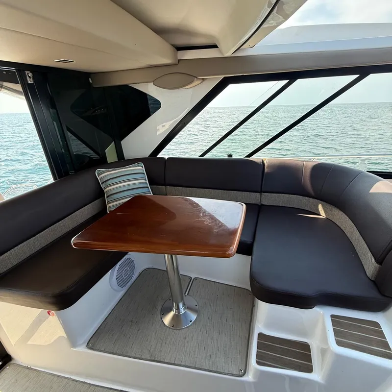 Slide: The Image of Interior of 2015 Regal 46 Sport Coupe yacht with seating and table, ocean view. - 14