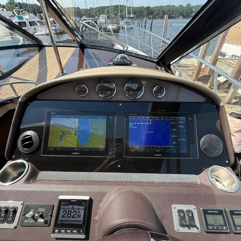 Slide: The Image of 2015 Regal 46 Sport Coupe dashboard with navigation screens and controls at a marina. - 16