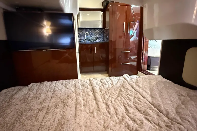 Slide: The Image of Interior of 2015 Regal 46 Sport Coupe with bed, TV, and kitchenette. - 23