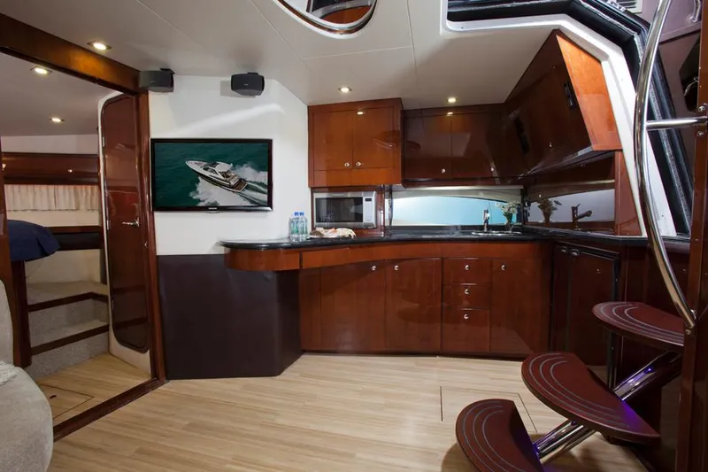 Slide: The Image of Manufacturer Provided Image: Luxurious interior of 2015 Regal 46 Sport Coupe yacht with modern kitchen and wooden cabinetry. - 33