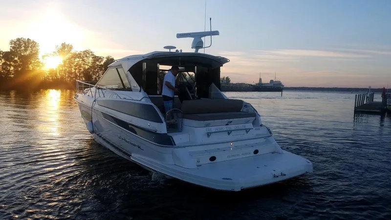 Slide: The Image of 2015 Regal 46 Sport Coupe yacht cruising at sunset on a serene lake. - 4