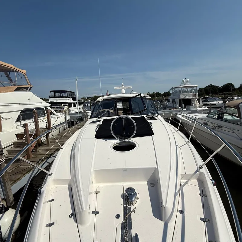 Slide: The Image of 2015 Regal 46 Sport Coupe yacht docked at marina under clear blue sky. - 5