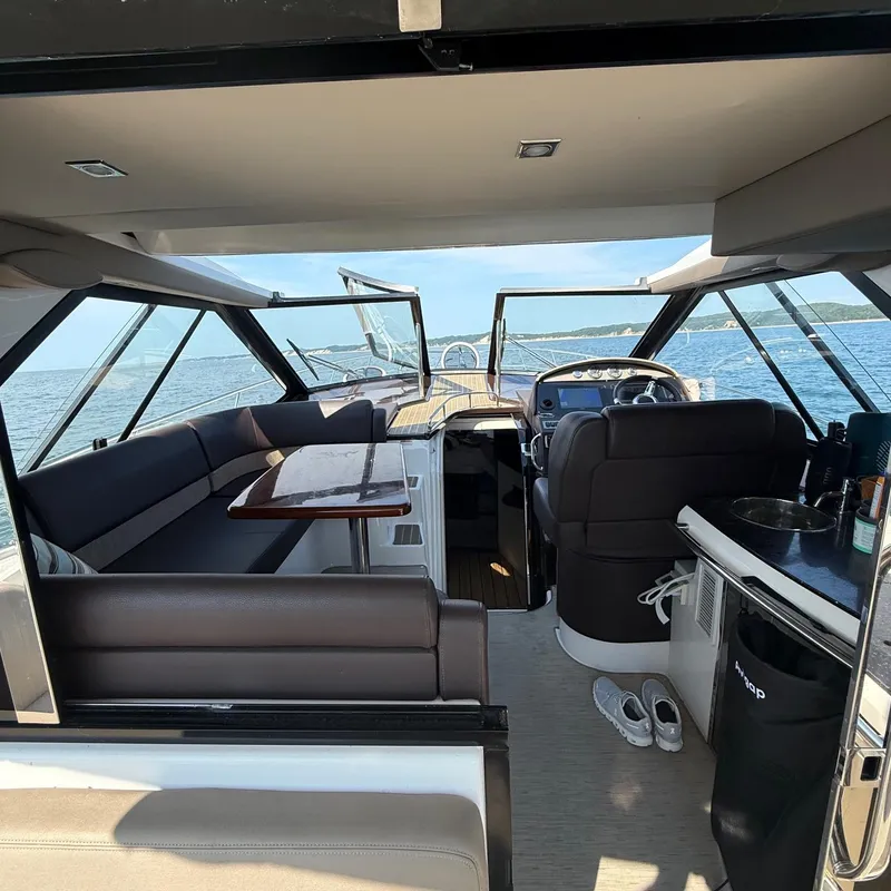 Slide: The Image of Interior of 2015 Regal 46 Sport Coupe yacht with seating, table, and helm. - 7