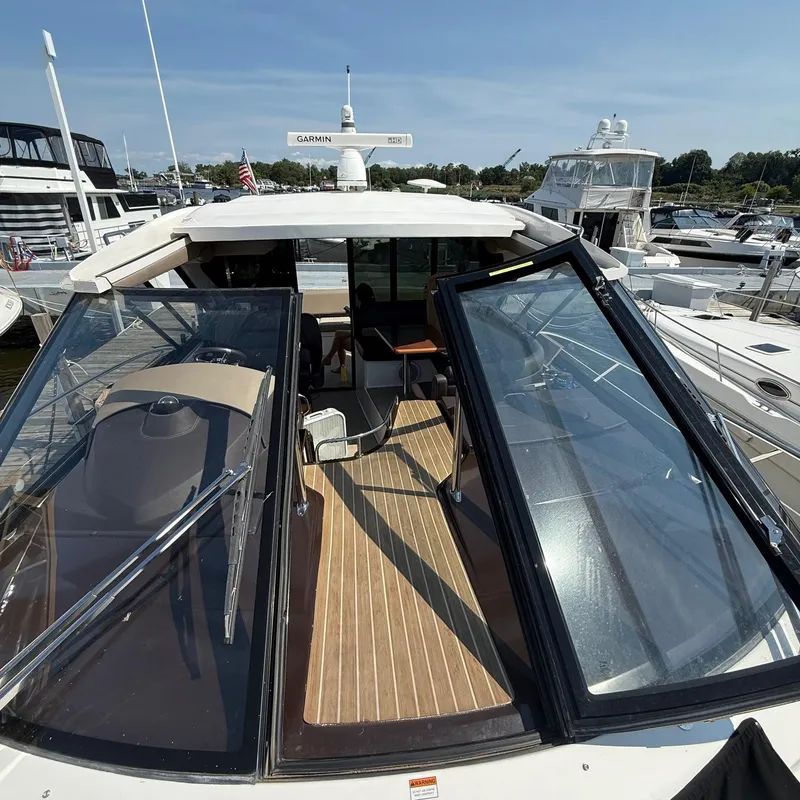 Slide: The Image of 2015 Regal 46 Sport Coupe yacht docked at marina, open sunroof, and spacious deck. - 8