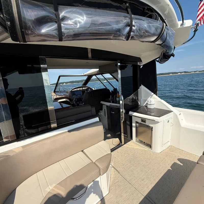 Slide: The Image of 2015 Regal 46 Sport Coupe yacht interior with seating and kitchenette on open water. - 9