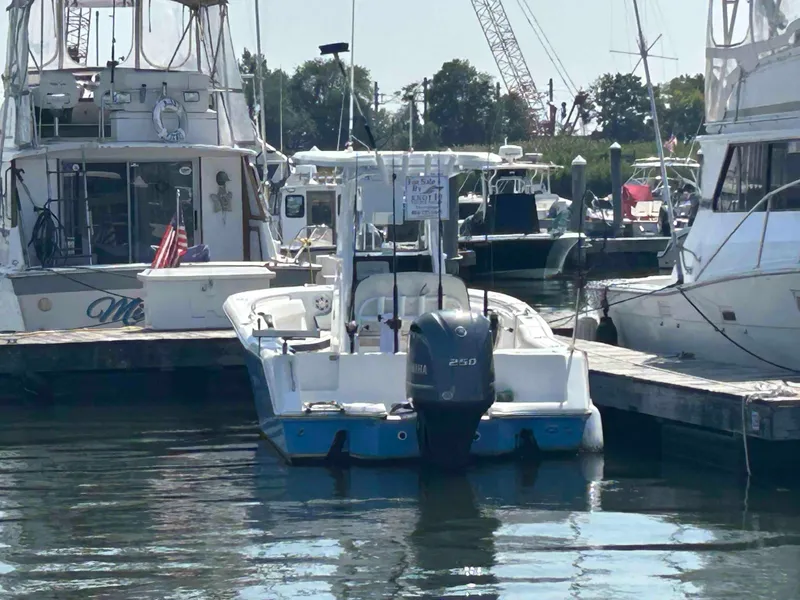 Slide: The Image of 2021 Tidewater 232 CC Adventure boat docked at marina with outboard motor. - 2