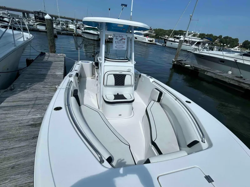 Slide: The Image of 2021 Tidewater 232 CC Adventure boat docked at marina, for sale sign visible. - 4
