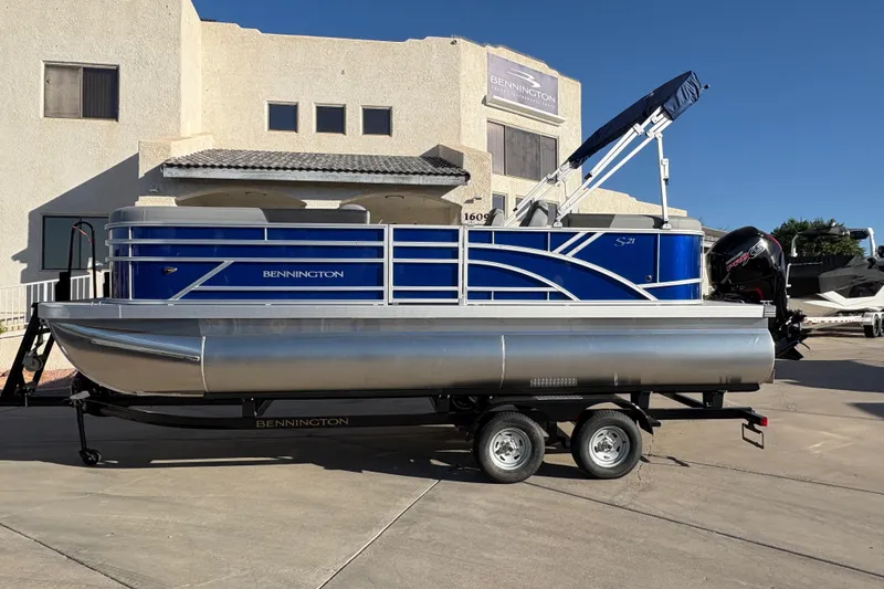 The Image of 2026 Bennington 21 SSR pontoon boat on trailer, parked outside a building. - 0
