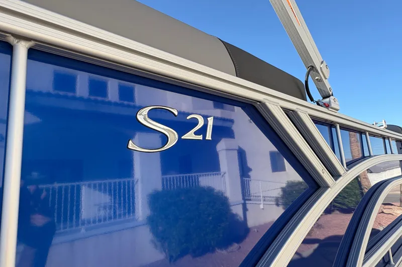 Slide: The Image of 2026 Bennington 21 SSR boat with sleek blue exterior and "S21" emblem. - 6