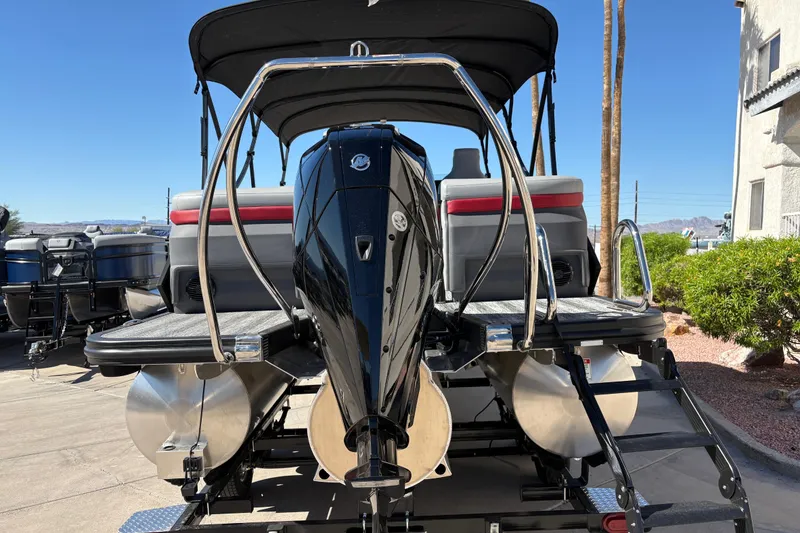Slide: The Image of 2026 Bennington 22 MFB pontoon boat with outboard motor, parked outdoors. - 4