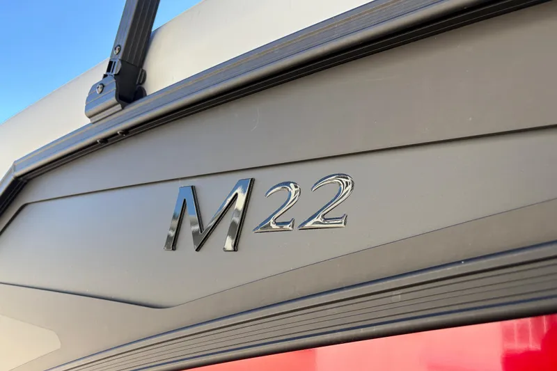 Slide: The Image of Close-up of 2026 Bennington 22 MFB boat model emblem, M22, on sleek black surface. - 5