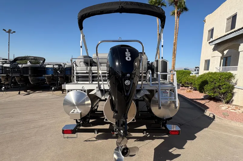 Slide: The Image of 2026 Bennington 21 SSB pontoon boat with 150 HP outboard motor, parked outdoors. - 3