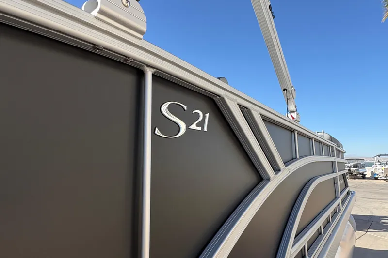 Slide: The Image of 2026 Bennington 21 SSB pontoon boat side view under clear blue sky. - 4