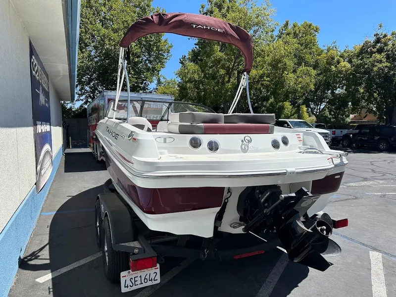 Slide: The Image of 2018 Tahoe 500 TF boat on trailer, parked outdoors, with maroon and white design. - 10