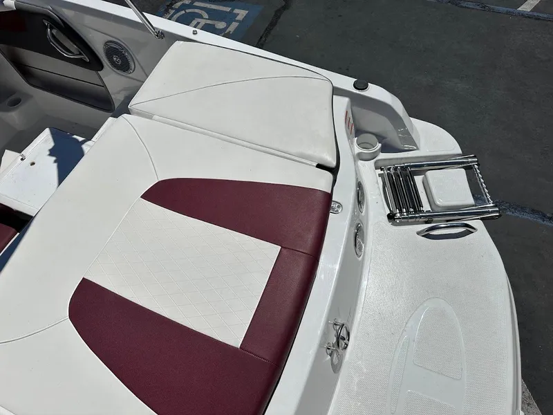 Slide: The Image of 2018 Tahoe 500 TF boat interior with maroon and white seating, cup holder, and foldable ladder. - 12