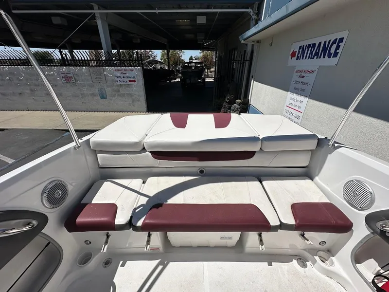 Slide: The Image of 2018 Tahoe 500 TF boat interior with white and maroon seating, docked near entrance sign. - 14