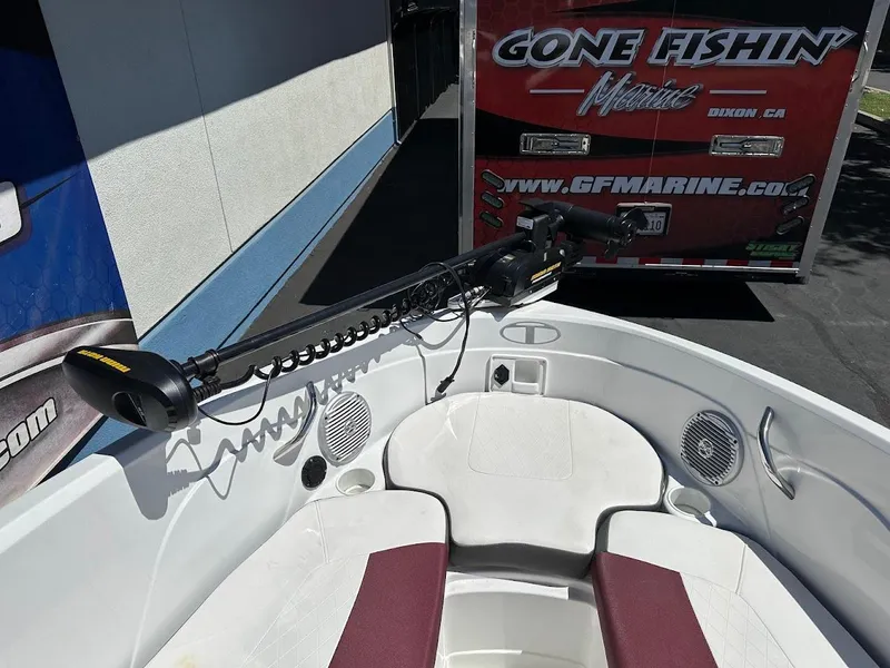 Slide: The Image of 2018 Tahoe 500 TF boat with trolling motor, parked near a "Gone Fishin' Marine" trailer. - 26