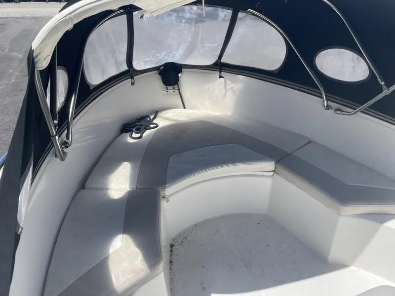Slide: The Image of 2006 Boston Whaler 210 Outrage boat interior with cushioned seating and canopy. - 4