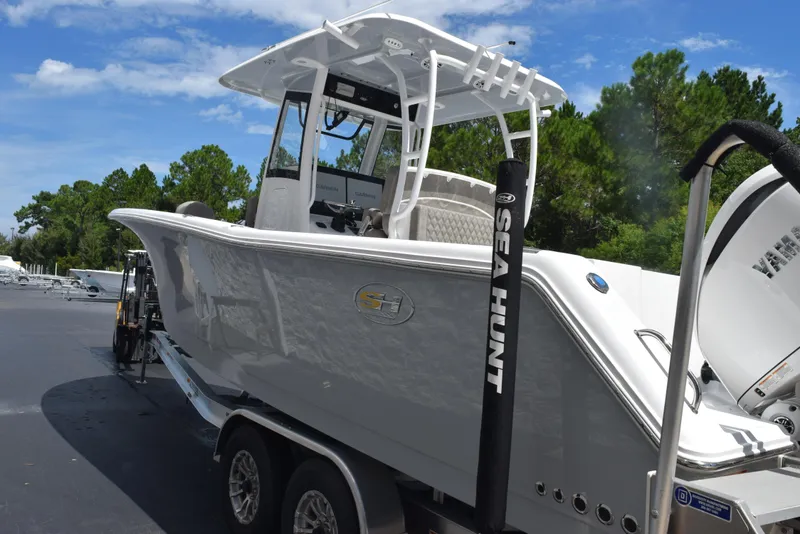 Slide: The Image of 2026 Sea Hunt Gamefish 28 boat with forward seating on a trailer, outdoors. - 5