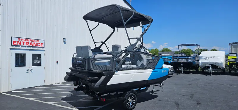 Slide: The Image of 2023 Sea-Doo Switch Sport Compact boat outside showroom entrance on a sunny day. - 4