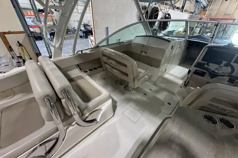 Slide: The Image of 2022 Boston Whaler 320 Vantage interior with seating and helm in a boatyard setting. - 15