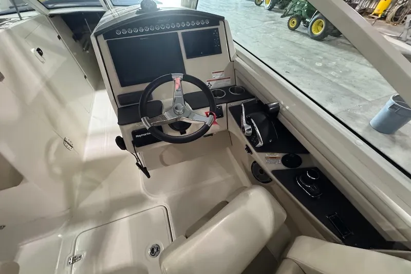Slide: The Image of 2022 Boston Whaler 320 Vantage helm with steering wheel and control panel. - 18
