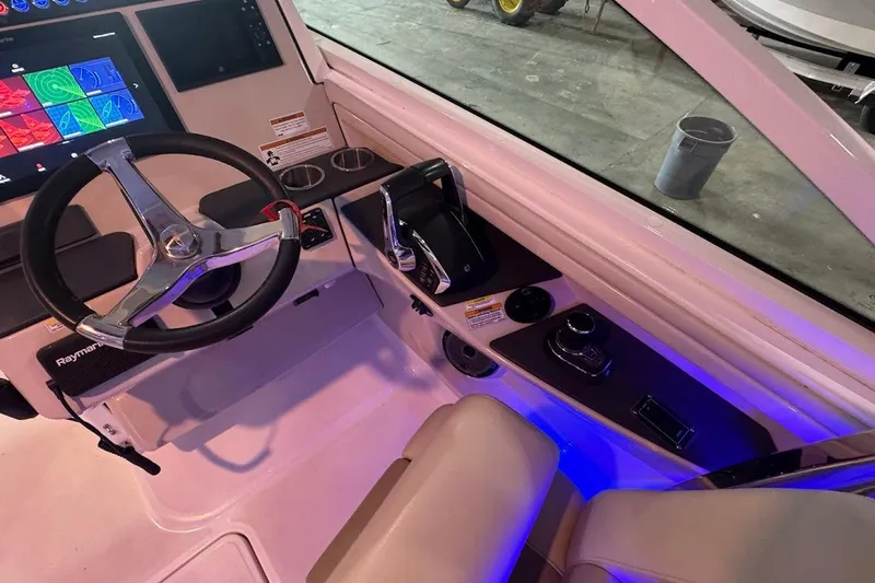 Slide: The Image of 2022 Boston Whaler 320 Vantage helm with steering wheel, controls, and navigation display. - 21