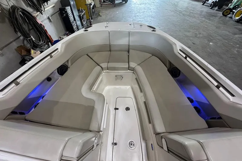 Slide: The Image of 2022 Boston Whaler 320 Vantage boat interior with cushioned seating and blue accent lighting. - 25