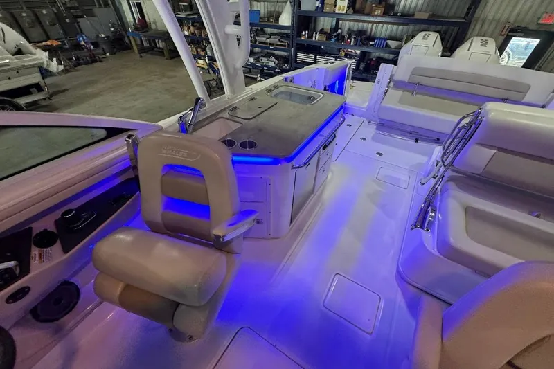 Slide: The Image of 2022 Boston Whaler 320 Vantage interior with blue LED lighting and seating arrangement. - 31