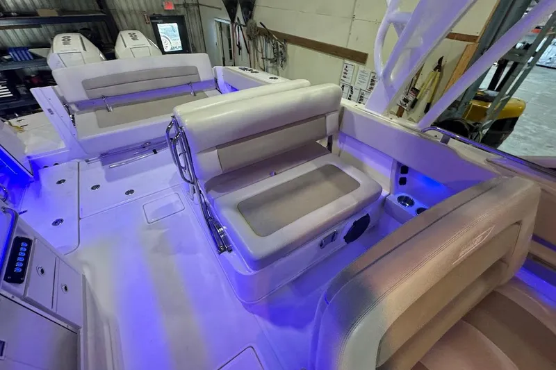 Slide: The Image of 2022 Boston Whaler 320 Vantage interior with seating and blue LED lighting. - 32