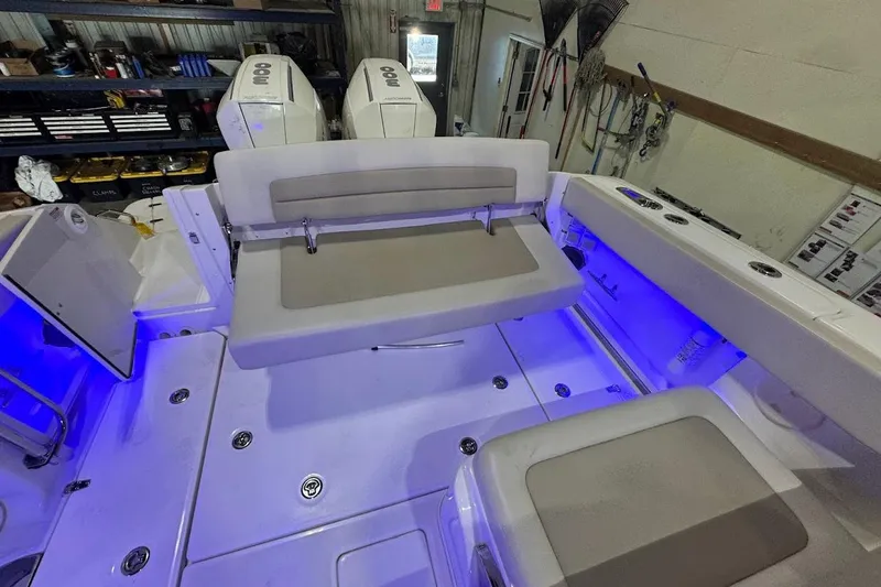Slide: The Image of 2022 Boston Whaler 320 Vantage interior with seating and blue LED lighting. - 33