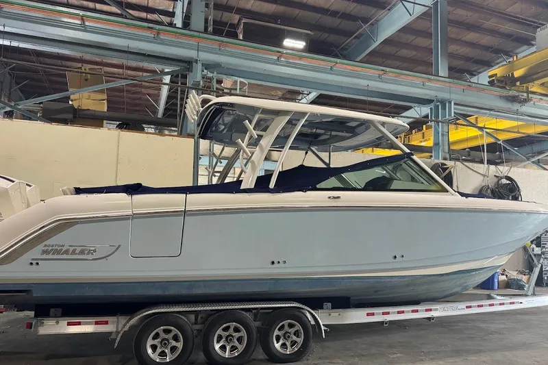 Slide: The Image of 2022 Boston Whaler 320 Vantage boat on trailer in industrial setting. - 6