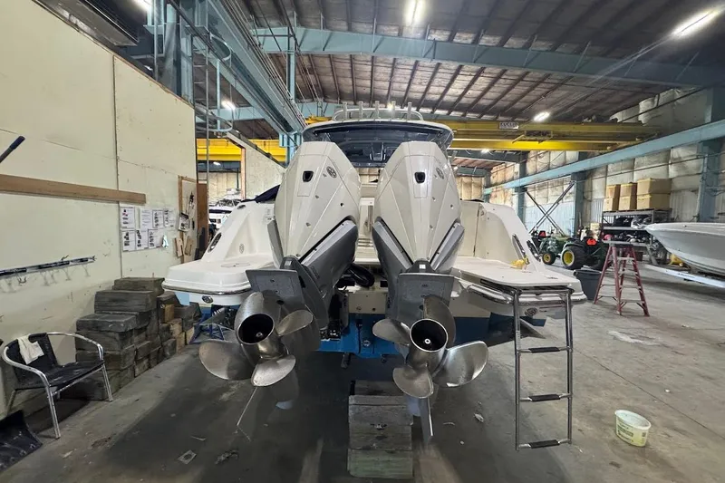 Slide: The Image of 2022 Boston Whaler 320 Vantage in a warehouse, showcasing dual outboard engines. - 8