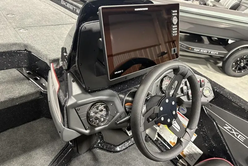 Slide: The Image of 2026 Skeeter ZXE20 boat dashboard with steering wheel and advanced navigation display. - 19