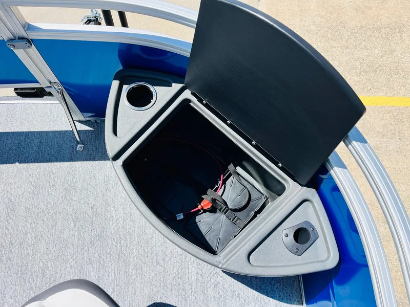 Slide: The Image of 2026 Sun Tracker Fishin' Barge 20 DLX storage compartment with cup holder and battery. - 17