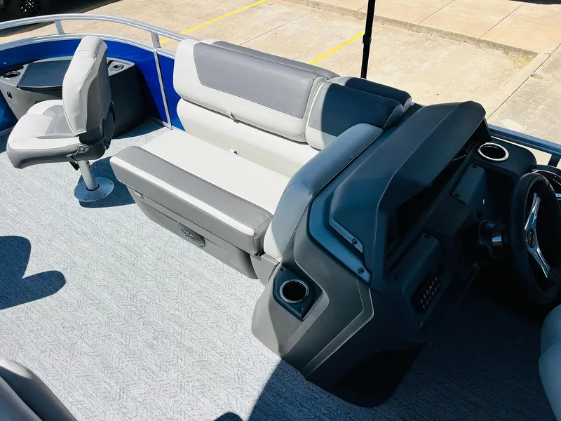 Slide: The Image of 2026 Sun Tracker Fishin' Barge 20 DLX interior with seating and helm, showcasing modern design. - 19