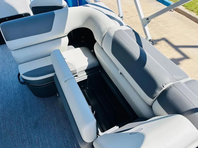 Slide: The Image of 2026 Sun Tracker Fishin' Barge 20 DLX interior seating with storage compartment open. - 27