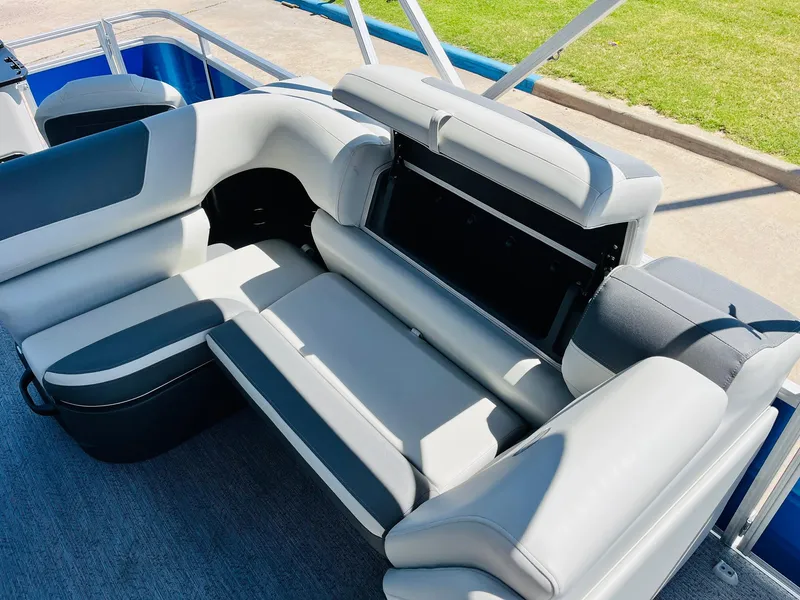 Slide: The Image of 2026 Sun Tracker Fishin' Barge 20 DLX interior seating with storage compartment open. - 28