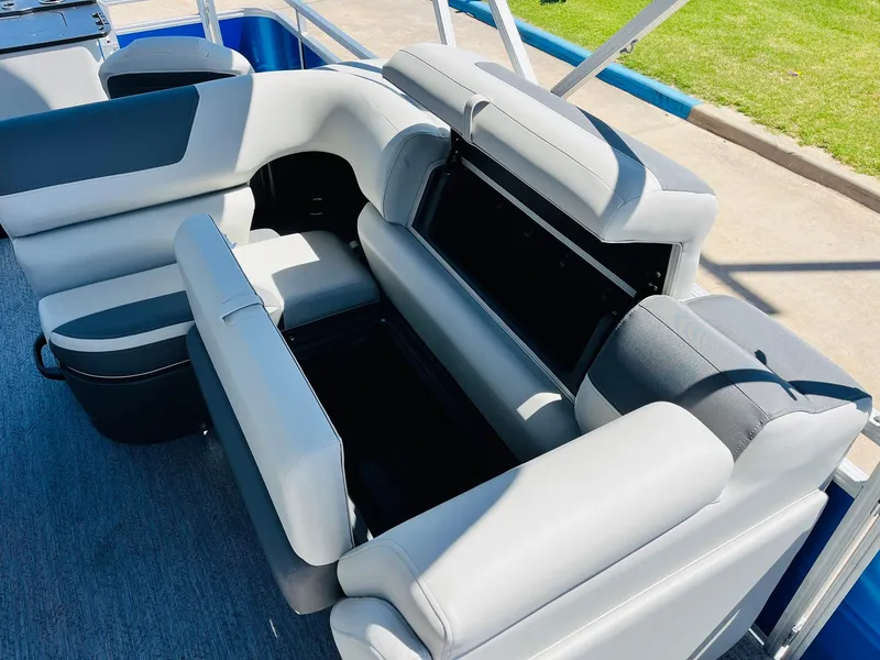 Slide: The Image of 2026 Sun Tracker Fishin' Barge 20 DLX interior seating with storage compartments open. - 29