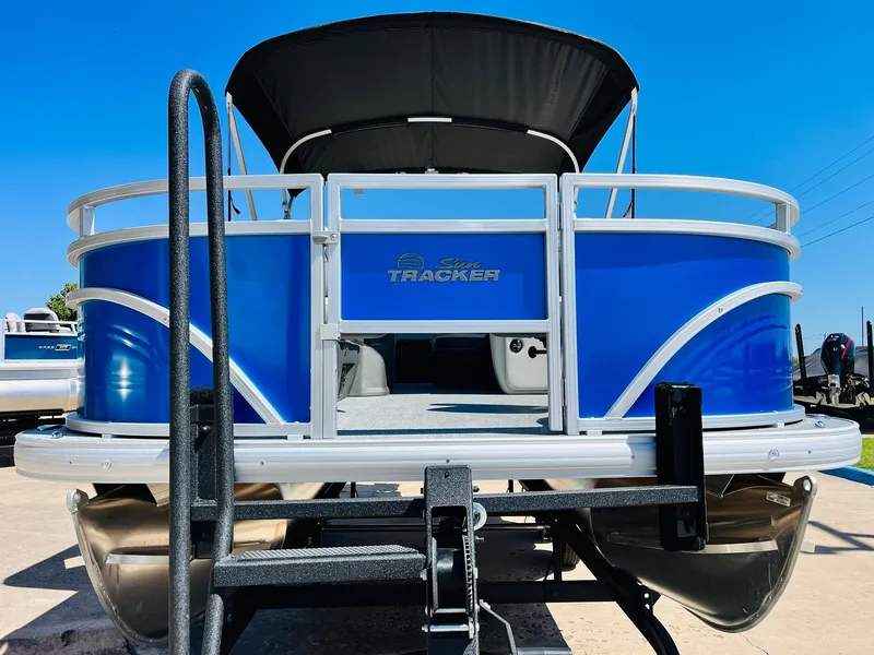 Slide: The Image of 2026 Sun Tracker Fishin' Barge 20 DLX pontoon boat, blue exterior, docked under clear sky. - 3