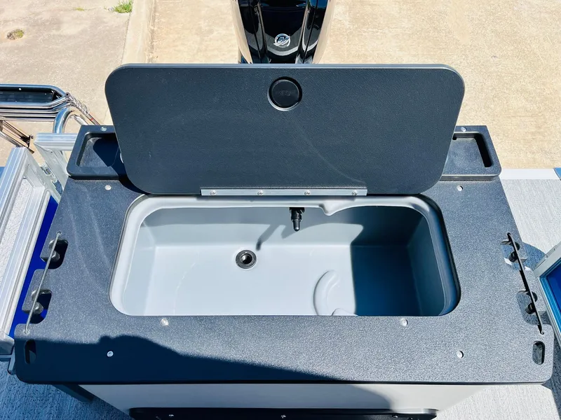 Slide: The Image of Livewell on 2026 Sun Tracker Fishin' Barge 20 DLX, open lid, gray interior. - 47