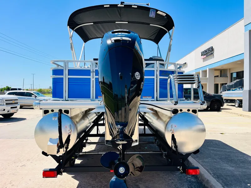 Slide: The Image of 2026 Sun Tracker Fishin' Barge 20 DLX pontoon boat with outboard motor, parked outdoors. - 7