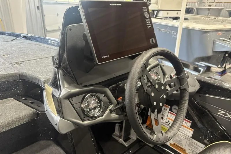 Slide: The Image of 2026 Skeeter ZXE20 boat dashboard with steering wheel and navigation display. - 16