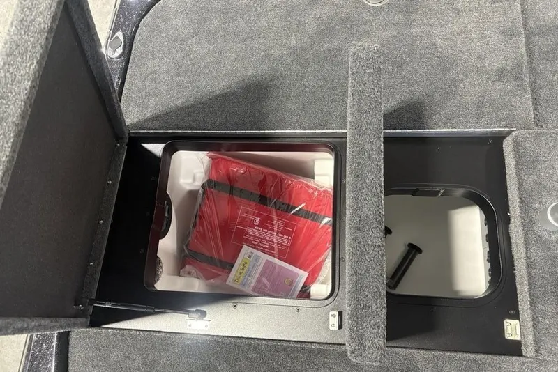 Slide: The Image of Storage compartment in 2026 Skeeter ZXE20 boat with red life jacket inside. - 34