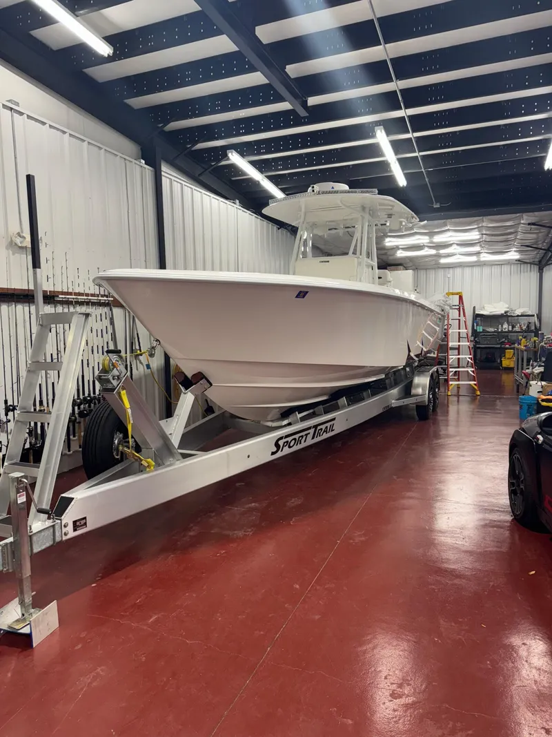 The Image of 2022 Contender 32 ST boat on trailer in a spacious indoor facility. - 1