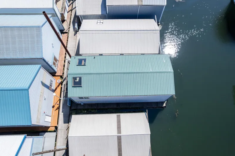 Slide: The Image of Aerial view of 1970 custom boathouses on calm water, featuring blue and white roofs. - 13