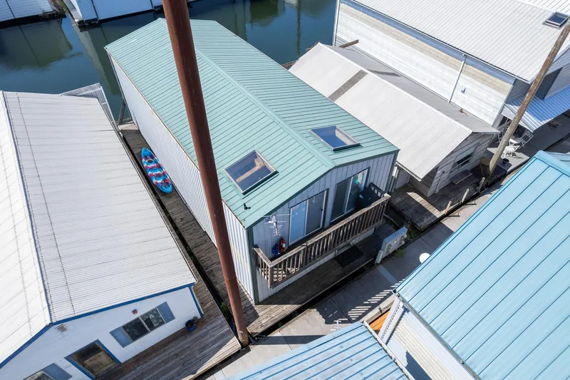 Slide: The Image of Aerial view of a 1970 custom boathouse with a green roof and skylights. - 14